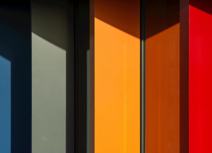 The colorful side of a building, with red, orange, green and blue panels