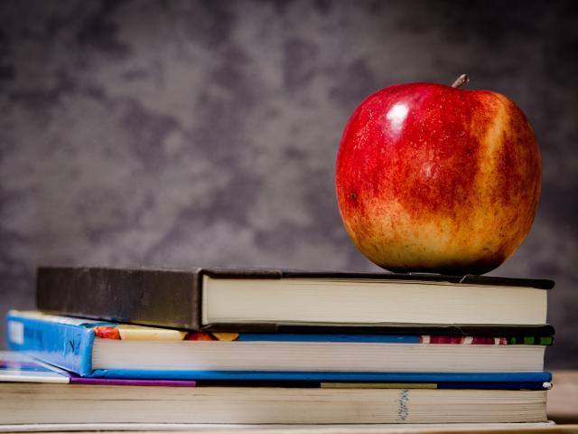 Books stacked with apple on top