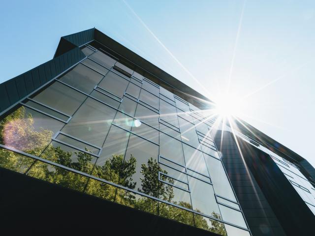 Building with sun and reflection of trees