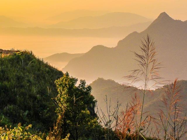 Group of people standing on a hilltop at sunset