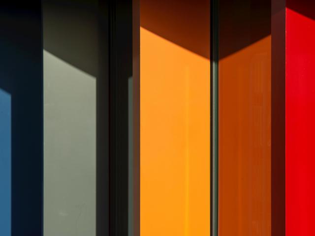 The colorful side of a building, with red, orange, green and blue panels