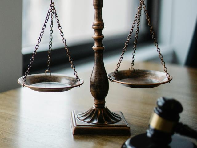 Scales and a gavel on a desk by a window