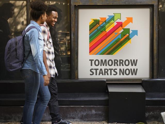 Students walking past an inspiring poster outside