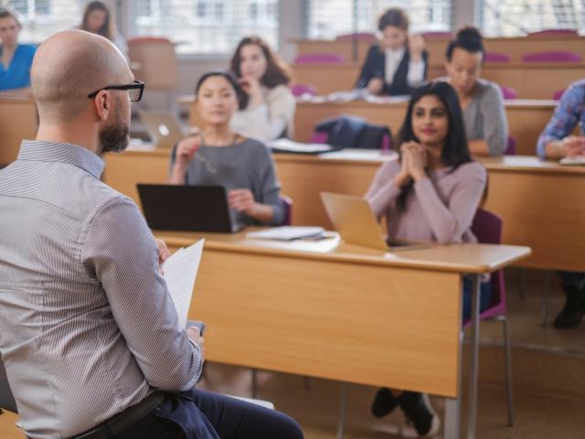 Man lecturing a group of university students
