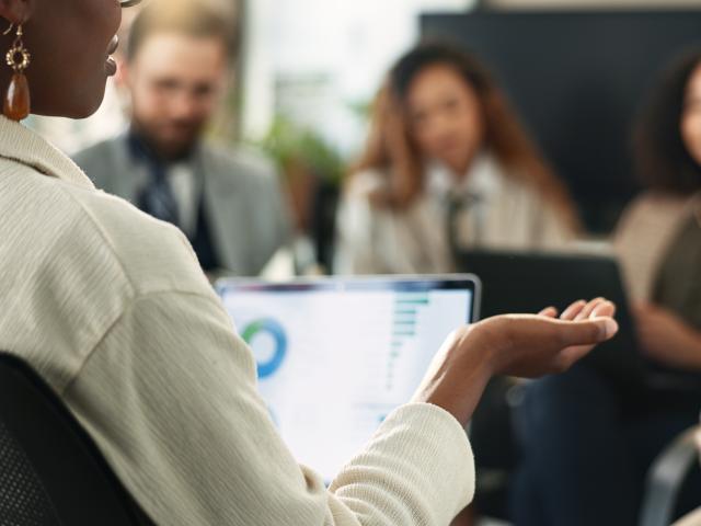 A woman addresses a small sitting group