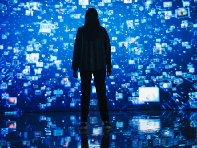 A person standing in front of a digital screen