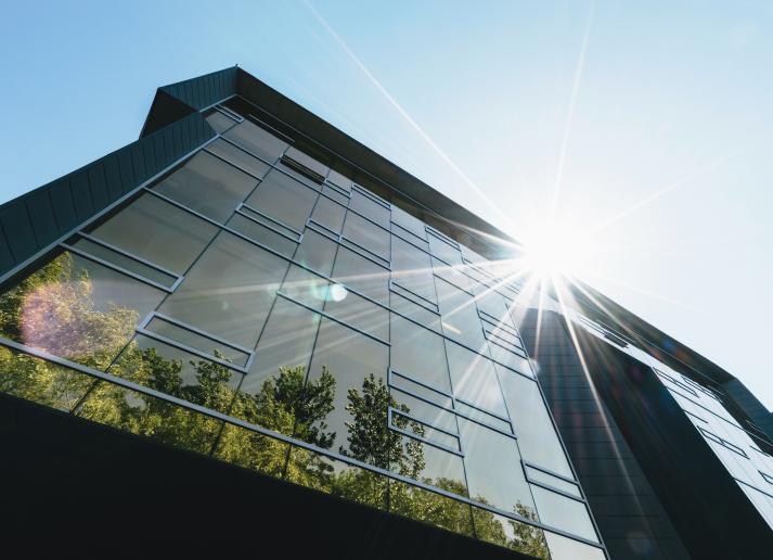 Building with sun and reflection of trees