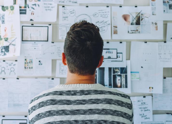 Man staring at wall of complicated papers