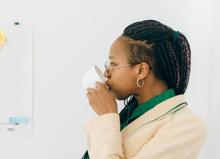 Woman looks at chart while sipping cup