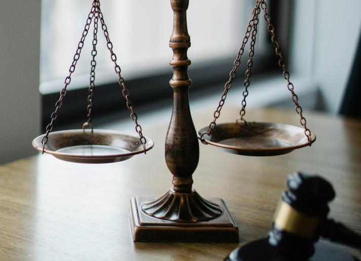 Scales and a gavel on a desk by a window