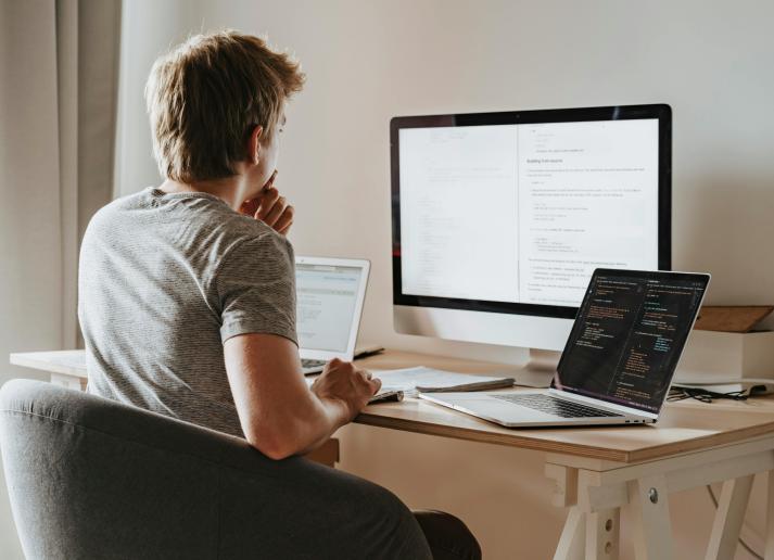 Man studying at three computers