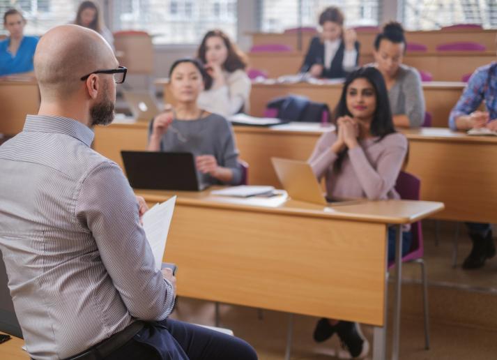 Man lecturing a group of university students