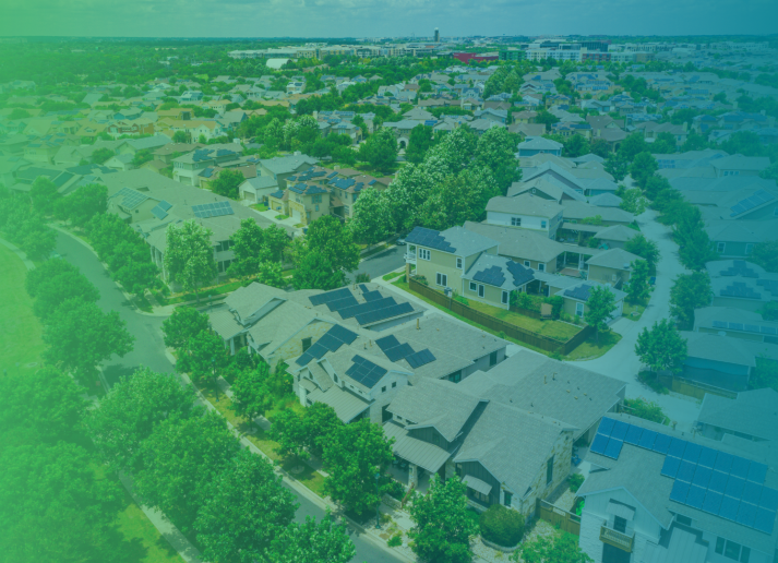 A blue and green gradient filter over a drone shot image of a green neighborhood.