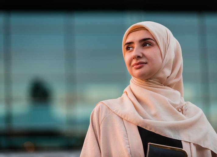 A woman in a cream headscarf looking to the left