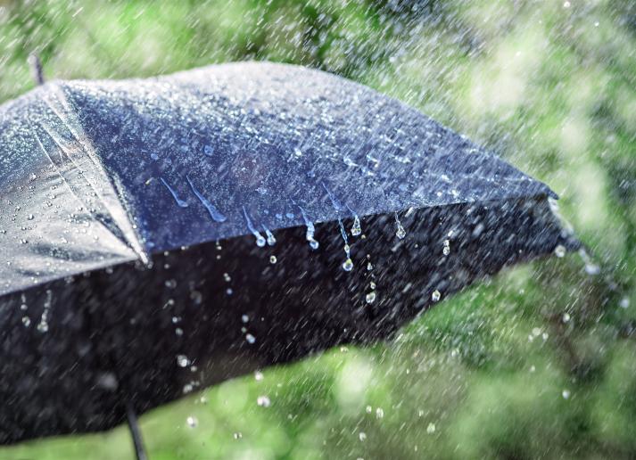Rain falling on a black umbrella