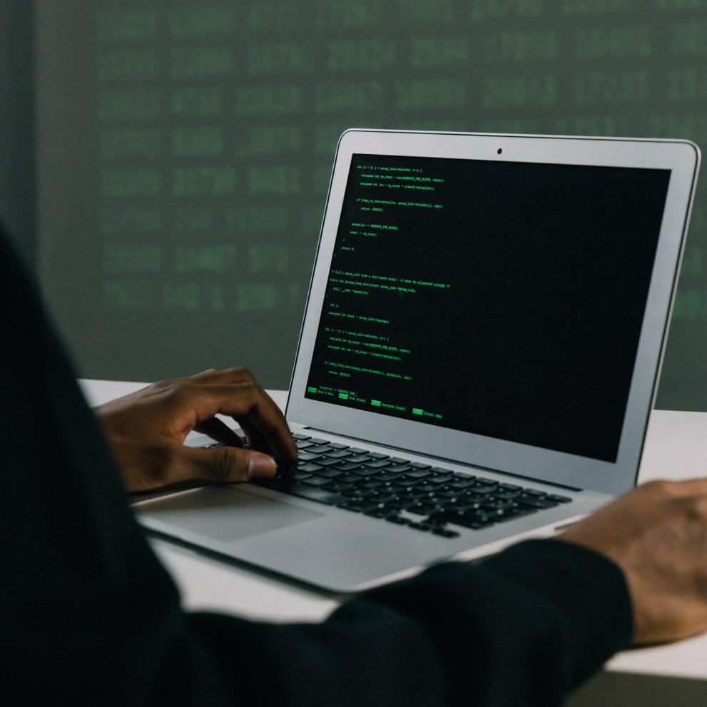 Man with computer that has green text