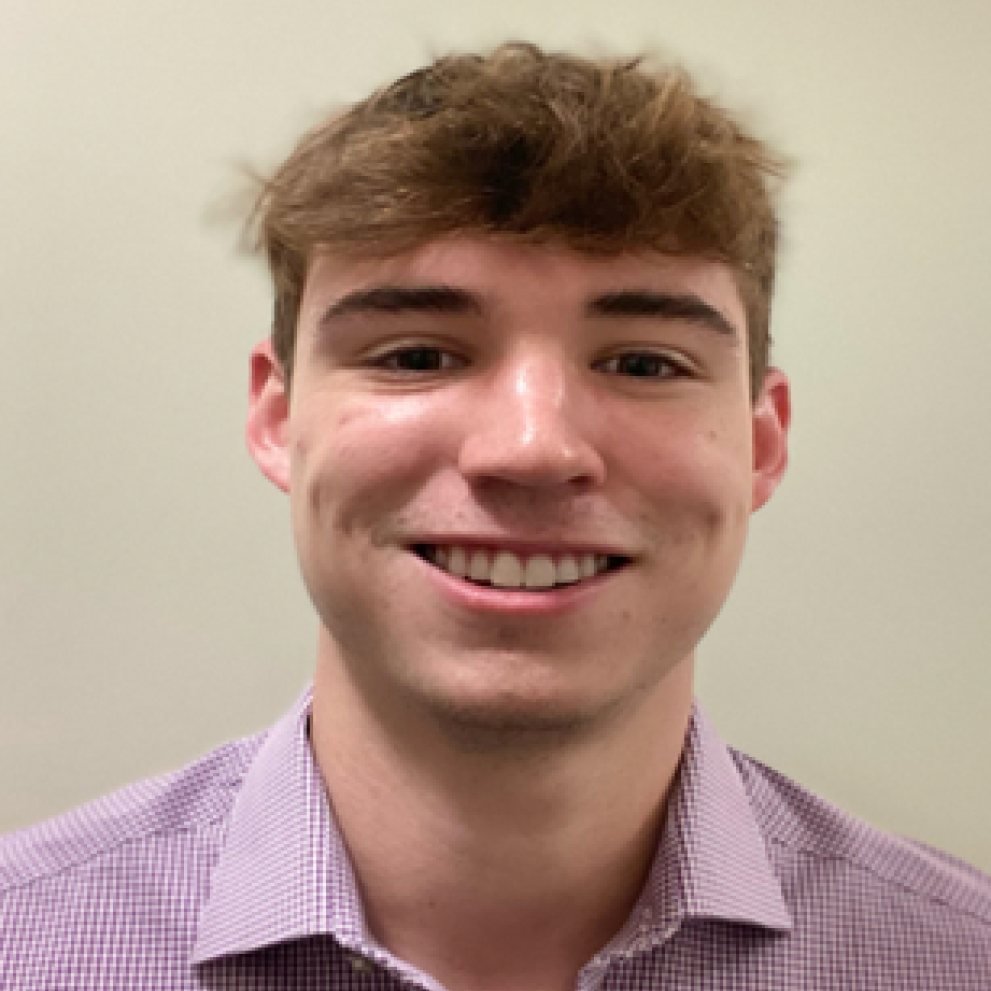 Man smiling and wearing a purple dress shirt