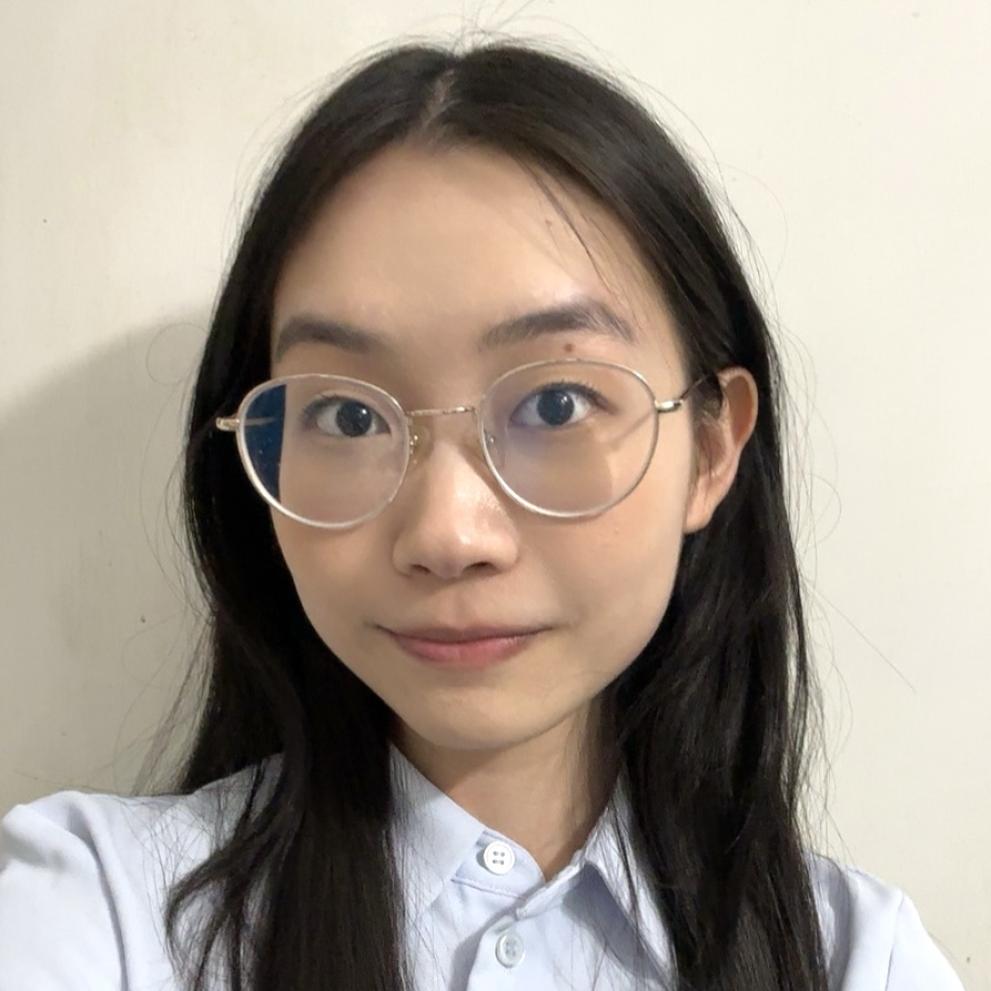 Woman with glasses smiling and wearing a white dress shirt