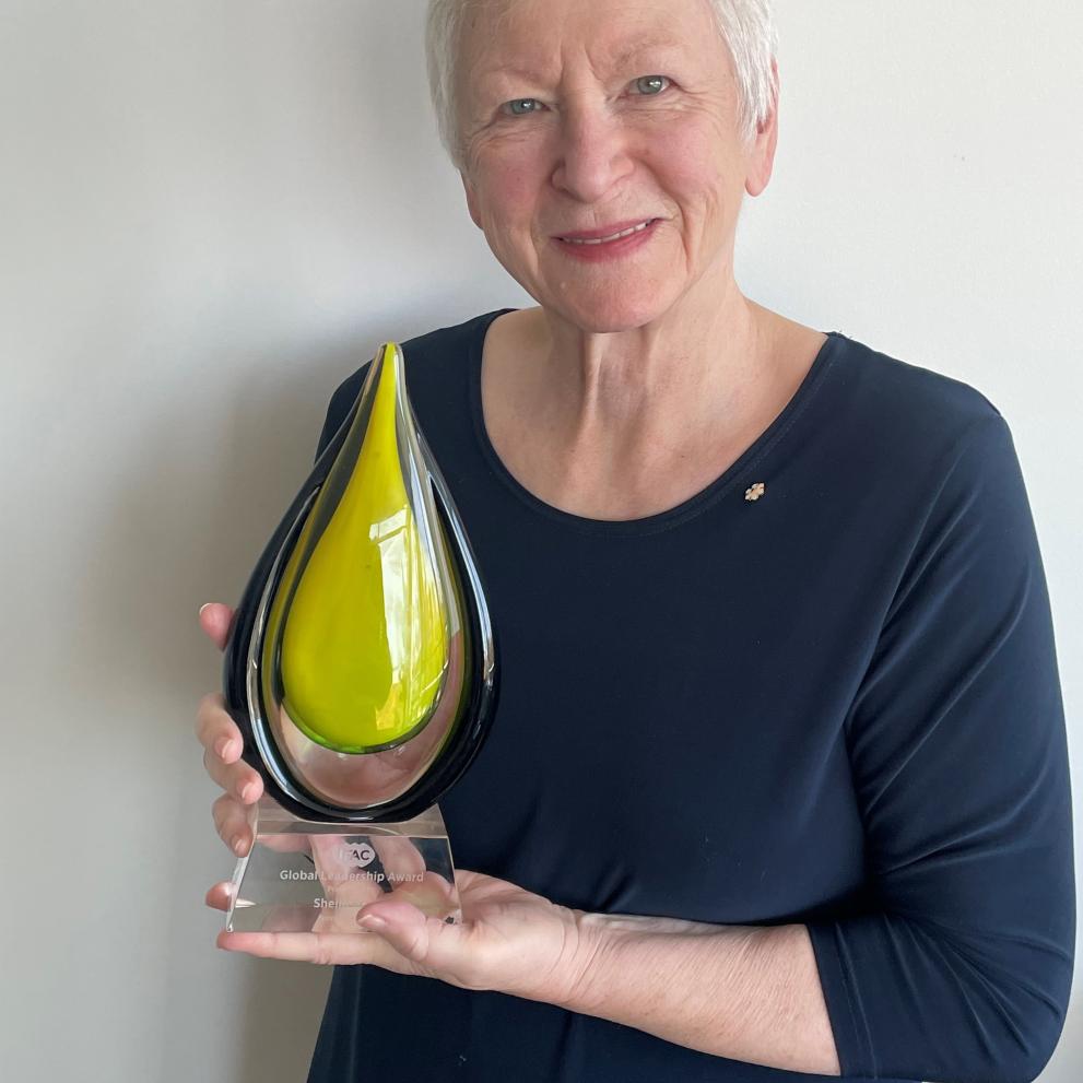 Woman smiling and holding a plaque