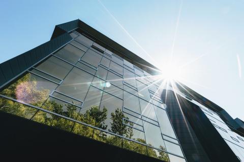 Building with sun and reflection of trees