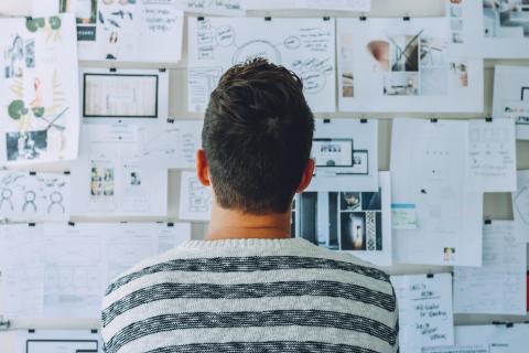 Man staring at wall of complicated papers