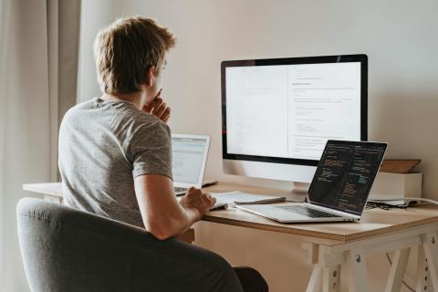 Man studying at three computers