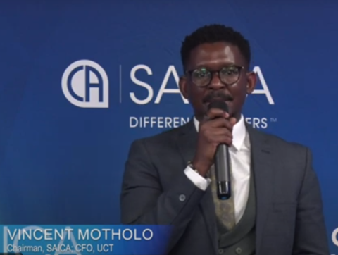 Vincent Motholo speaking in a microphone with the SAICA logo in the background