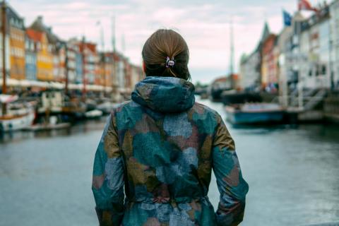 A woman with her back to the camera looks out at a dock in Denmark