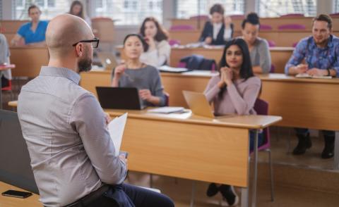 Man lecturing a group of university students