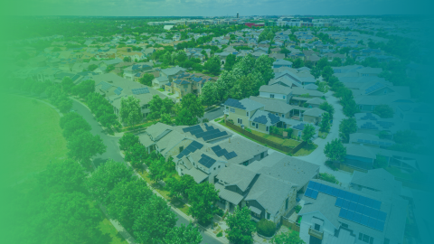 A blue and green gradient filter over a drone shot image of a green neighborhood.