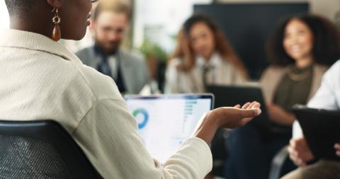 A woman addresses a small sitting group