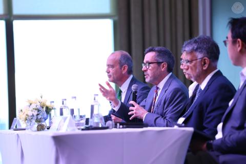 A man on a panel speaks into a microphone