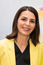 Adriana Spirodon, a woman wearing a yellow blazer